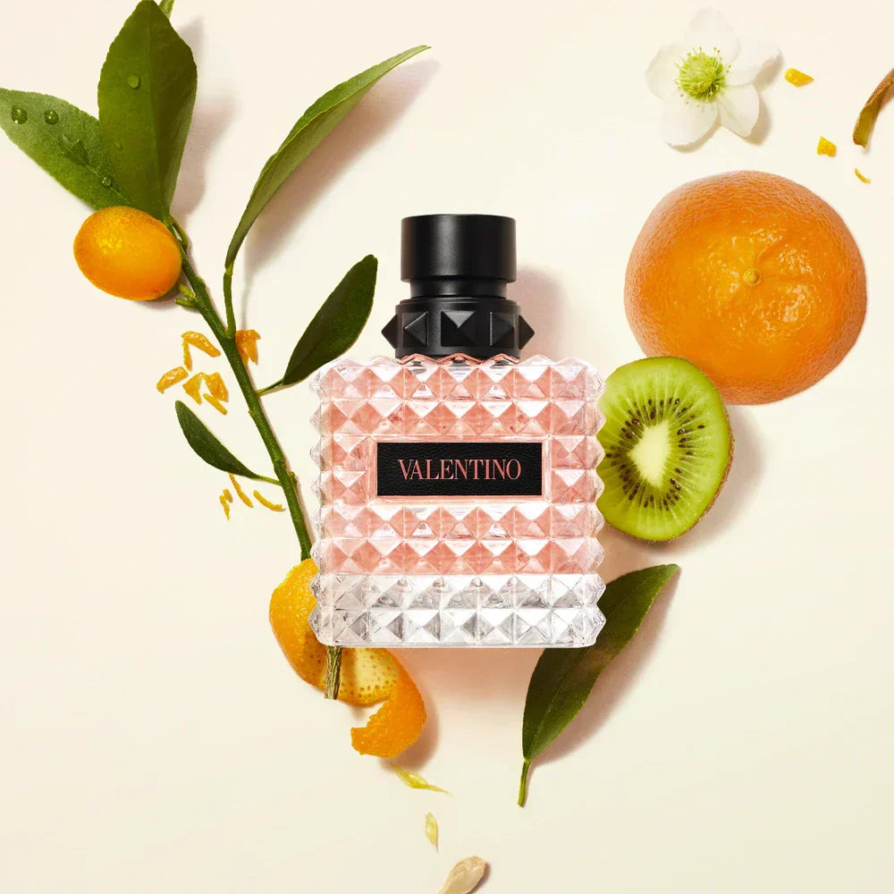 Valentino bottle with fruits and leaves on a light background